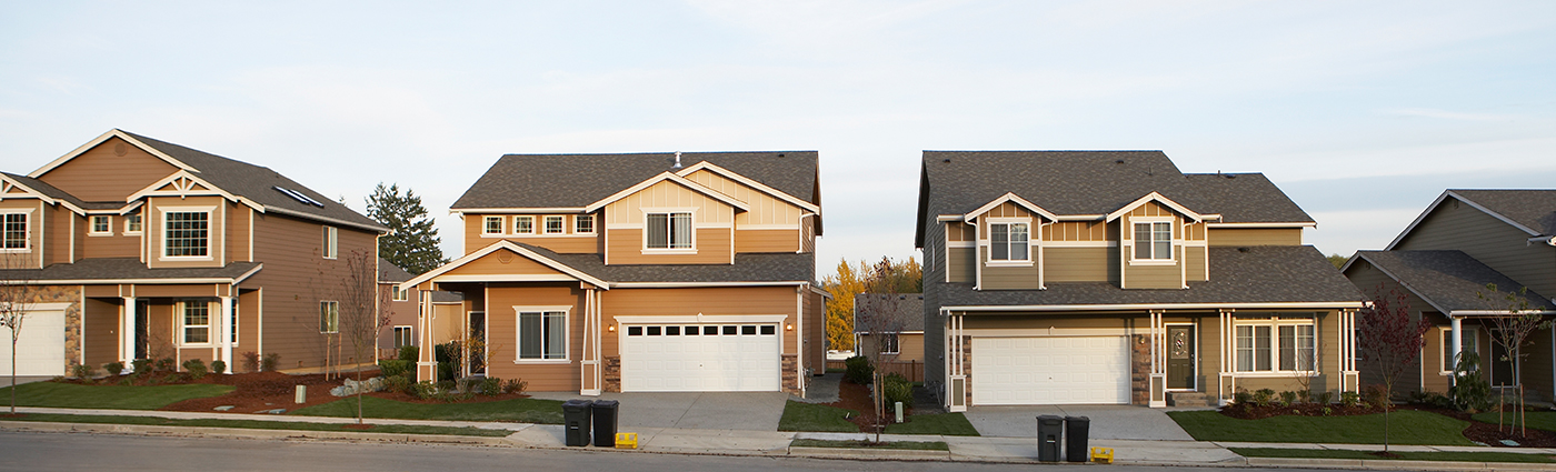 A picture of 4 detached houses in a neighbourhood.